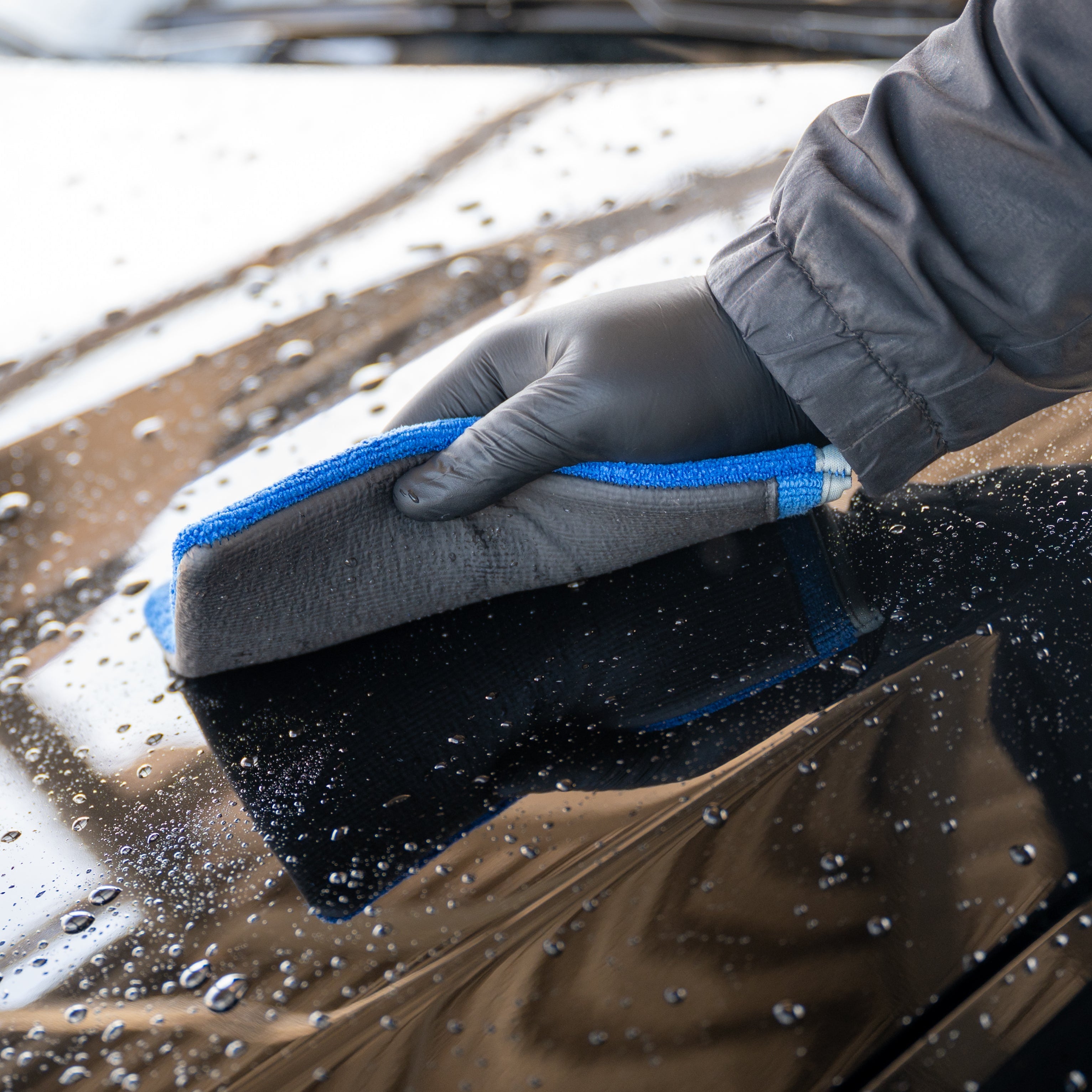 Person cleaning a car with a Clay Mitt