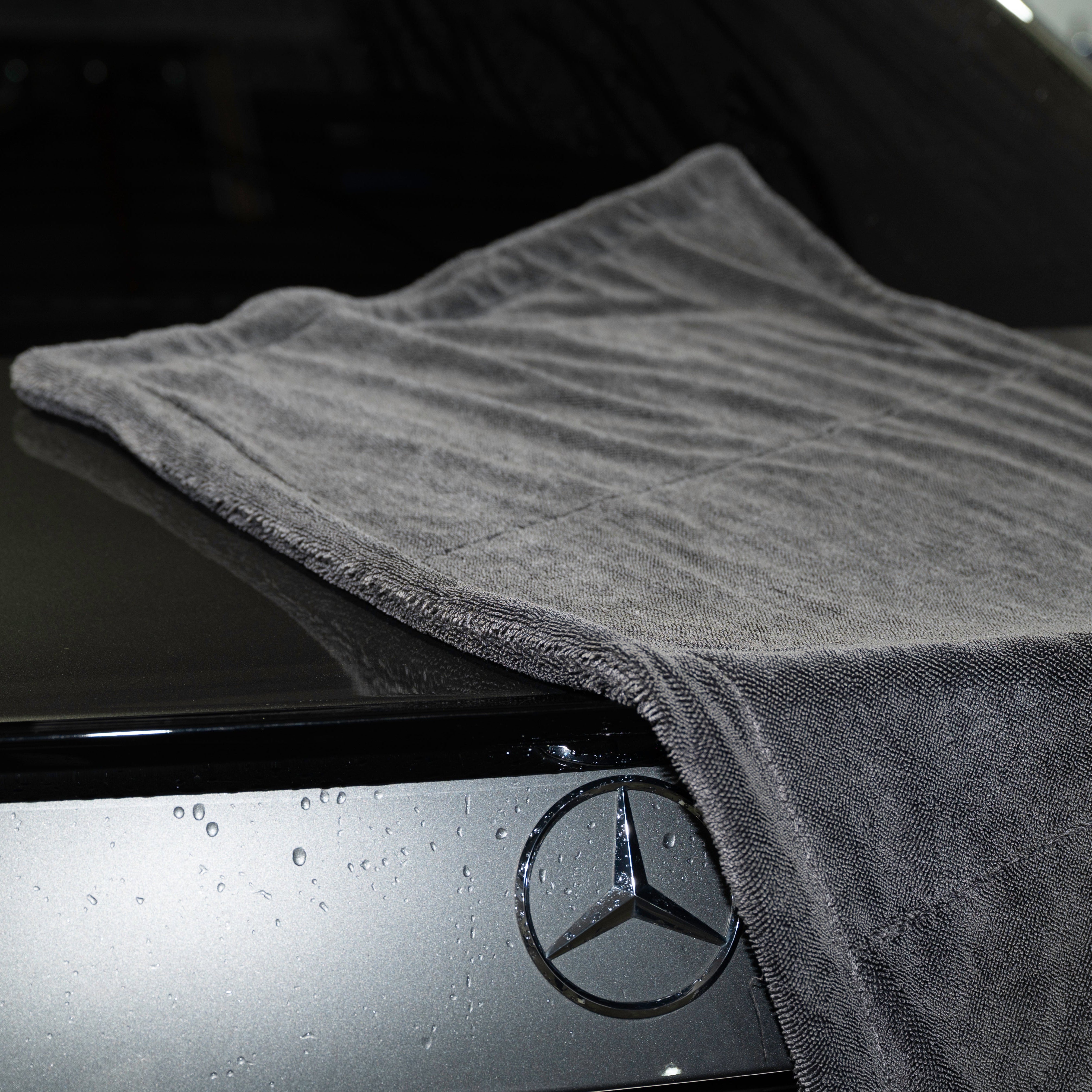 Gray towel draped over a Mercedes car hood