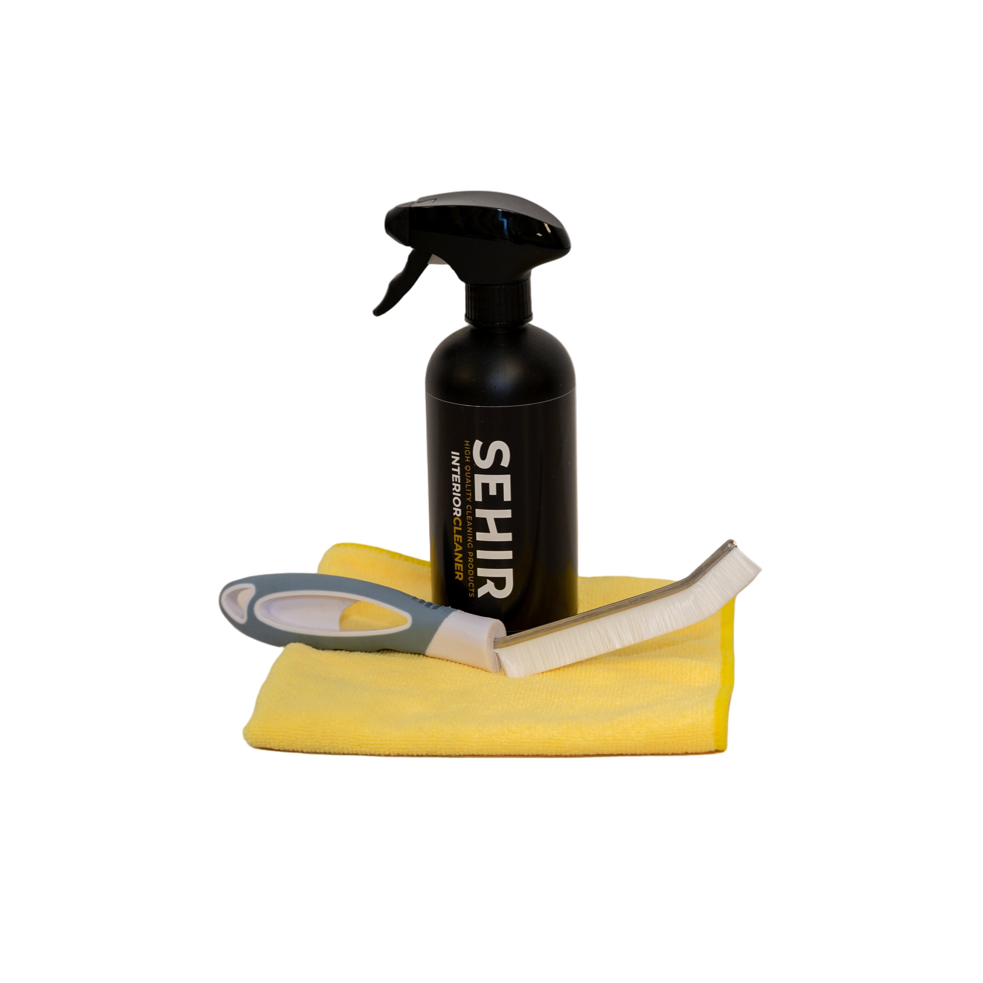 Cleaning spray bottle, cloth, and brush on a beige surface with a white background