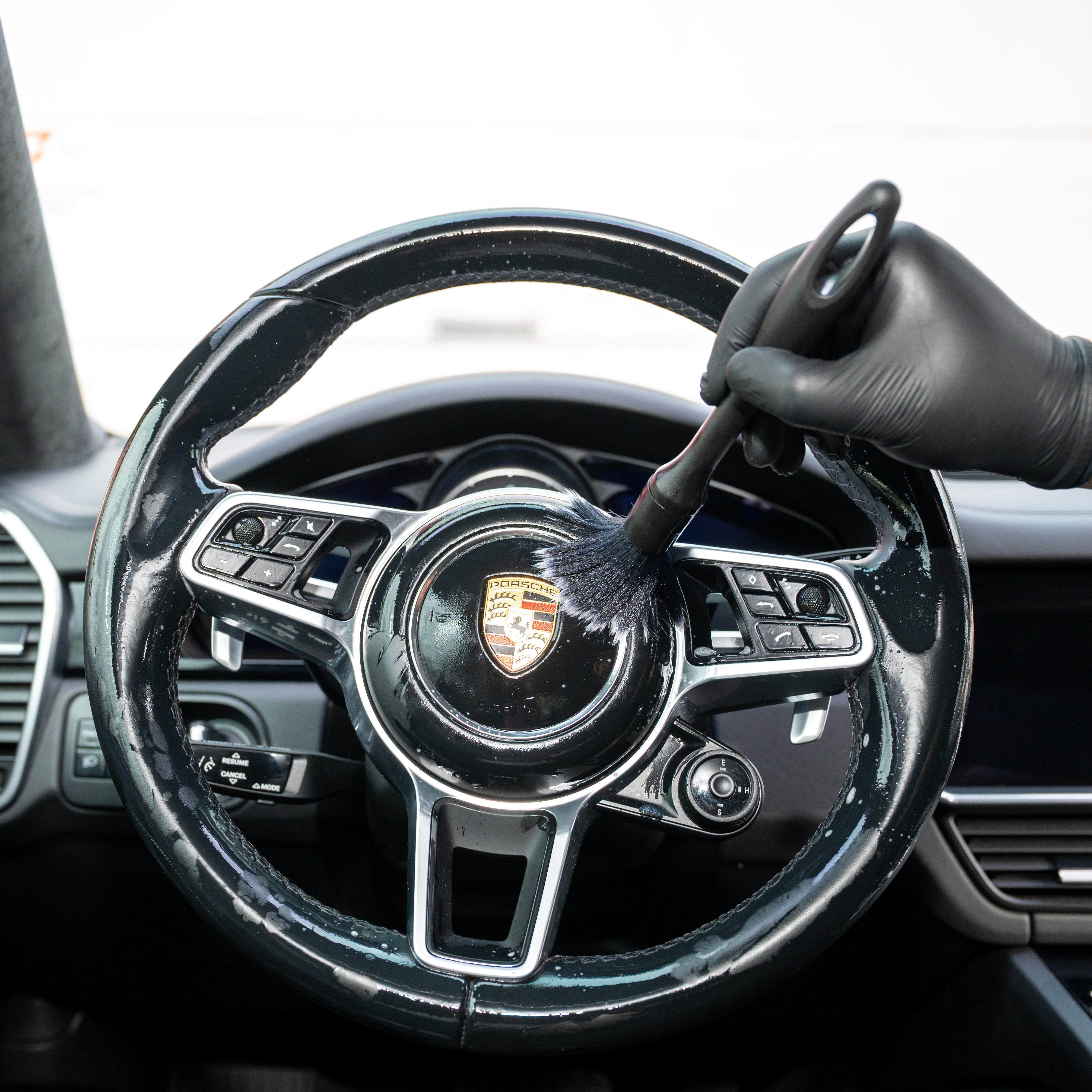 Steering wheel of a Porsche car cleaning with Interior Soft Brush Set
