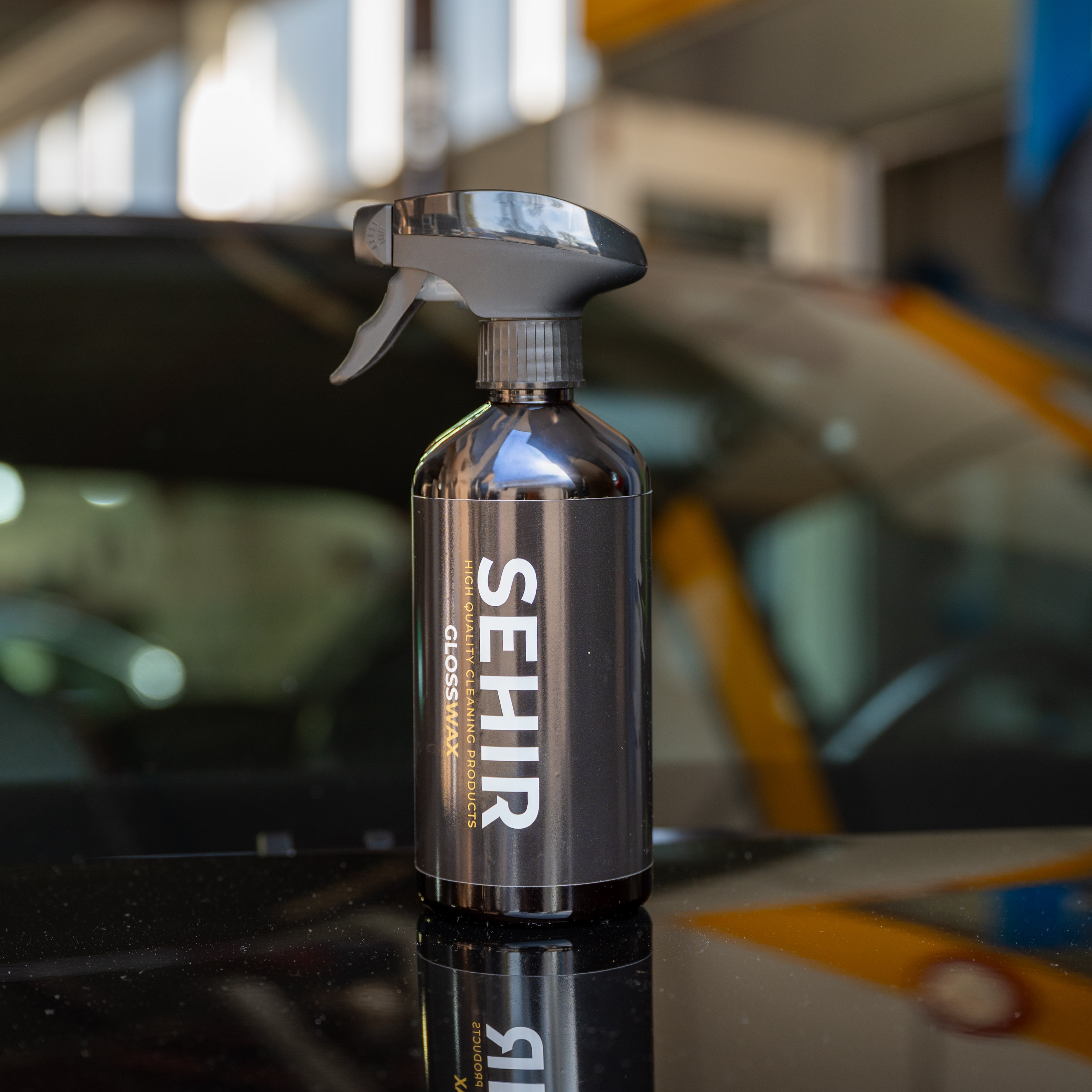 Spray bottle with 'SEHIR' branding on a car dashboard