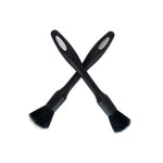 Two black brushes with bristle heads on a white background