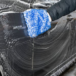 Person washing a car with a blue Microfiber Wash Mitt, focusing on the soapy water and sponge texture.