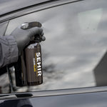 Person cleaning a car window with a SEHIR branded cleaning product.