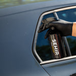 Person using a spray can labeled 'SEHIR' on a car exterior