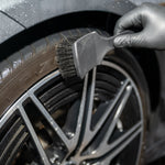 Tire Brush used to clean a tire with a black glove